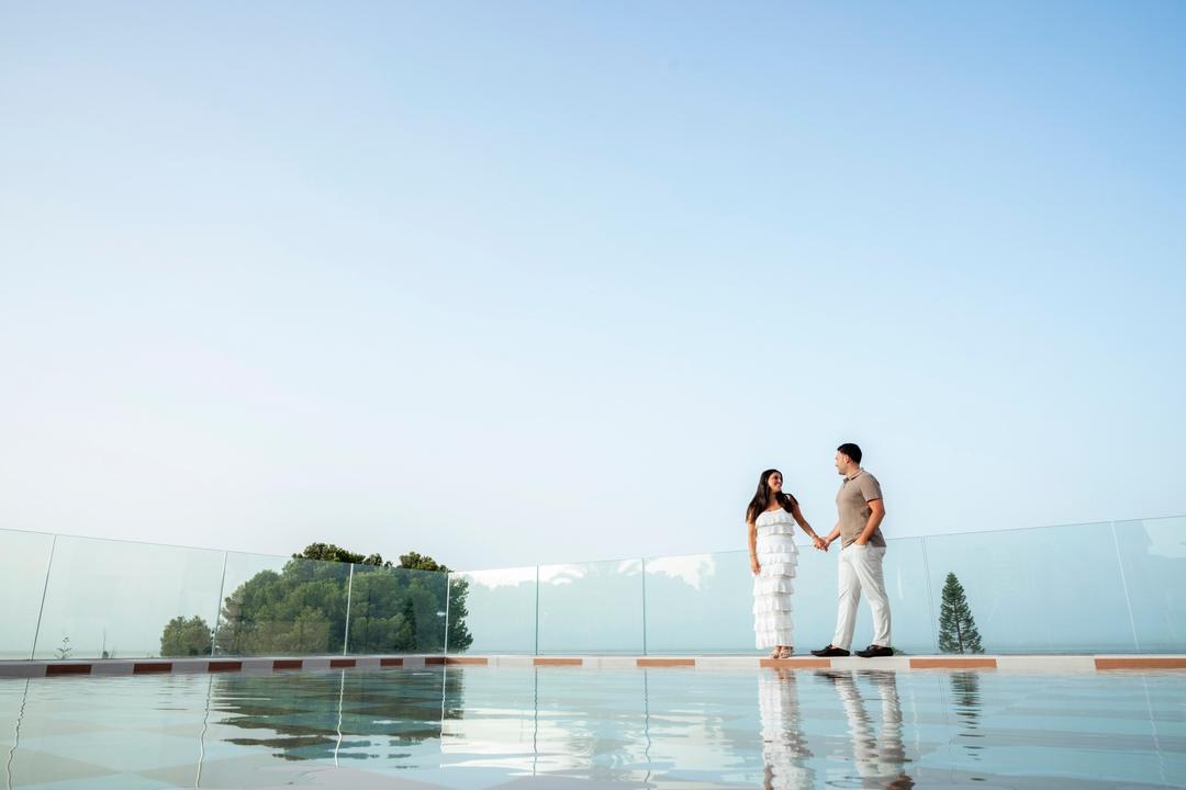 Couple holding hands at the edge of an infinity pool